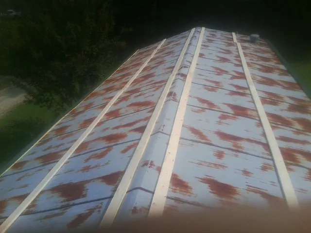 Rusted metal roof panels with new wood purlins before replacement — Storm Damage Roof Repair in Douglassville by Roofing Brothers