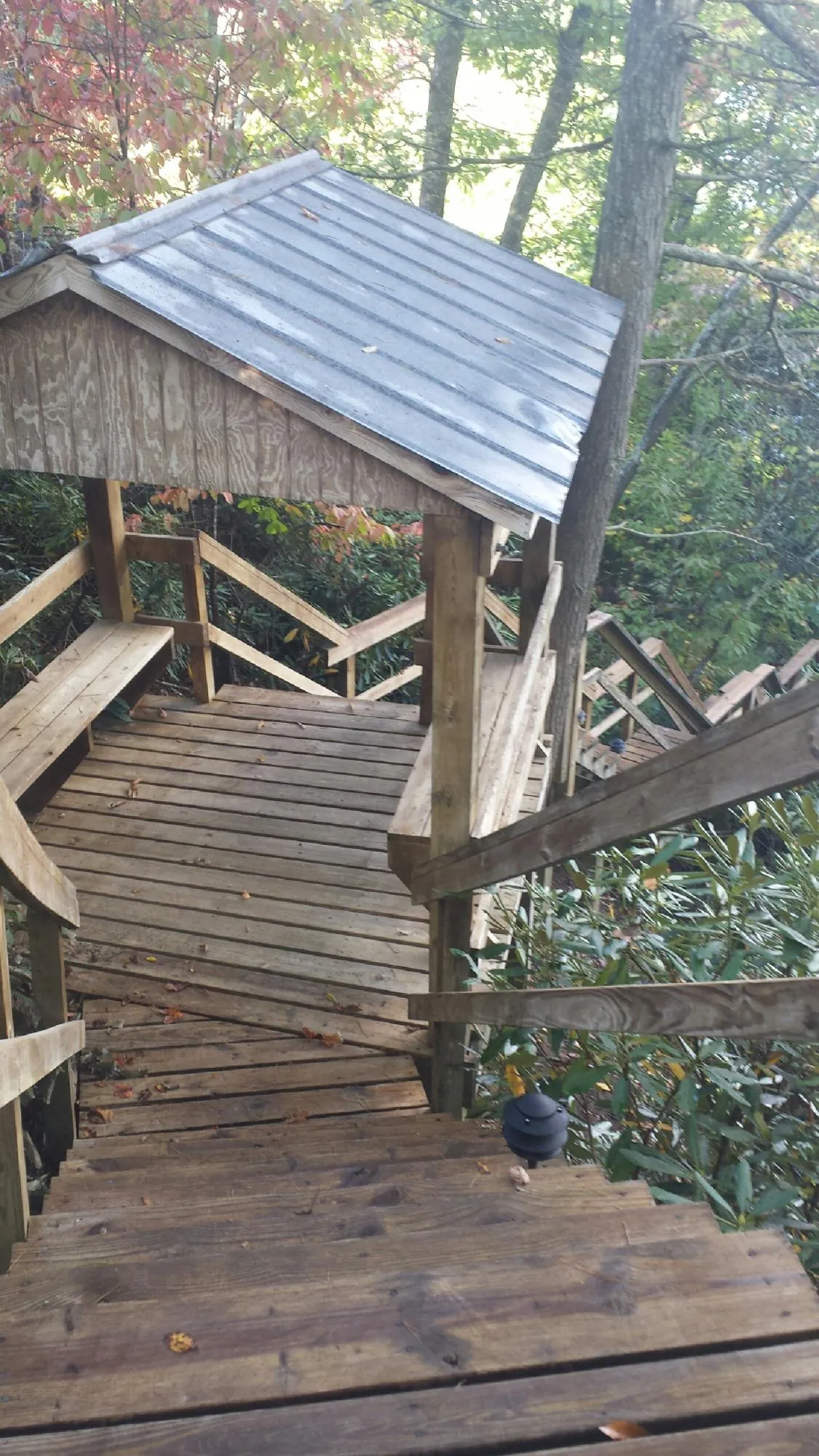 Metal roofed shelter over wooden steps on a wooded walkway — Skylight Repair & Installation work by our crew in Douglassville