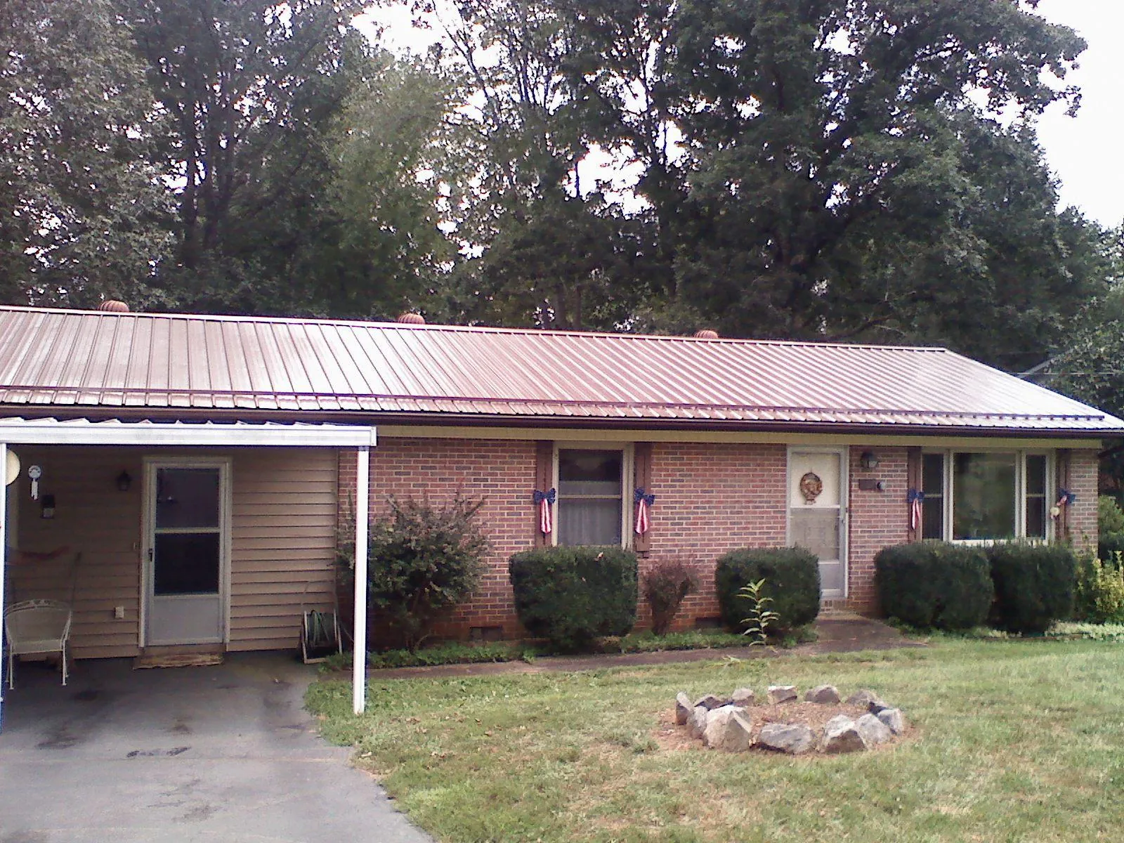 Bronze metal roof and carport on a brick ranch home — Roof Repair work by our crew in Douglassville