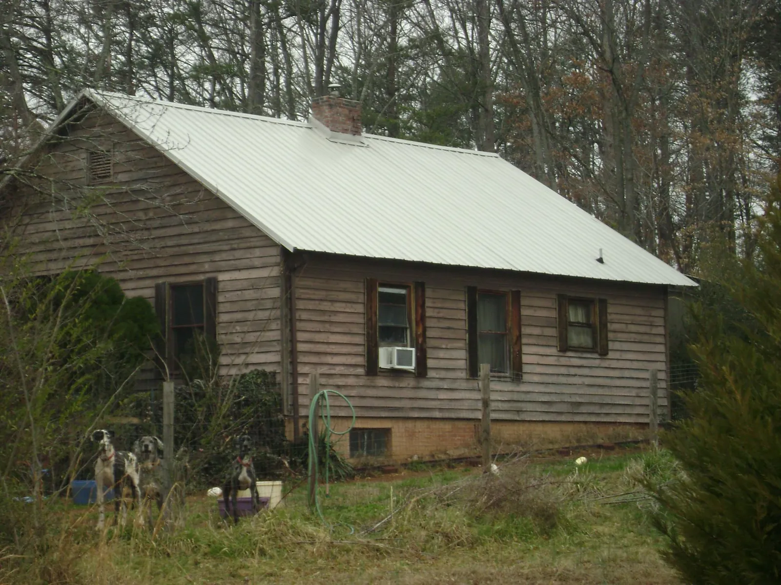 White metal roof on an old wood sided farmhouse, from a Asphalt Shingle Roof Repair job in Douglassville